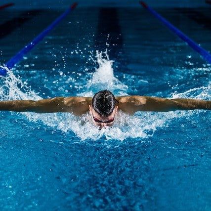 This is a picture of a man swimming in a swimming pool.